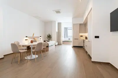 a living room with a table and chairs and a bedroom at Suite Deluxe Valencia - Ciudad de las Artes in Valencia
