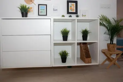 a white cabinet with potted plants on it at Apartamento acogedor frente a Torres de Serrano in Valencia