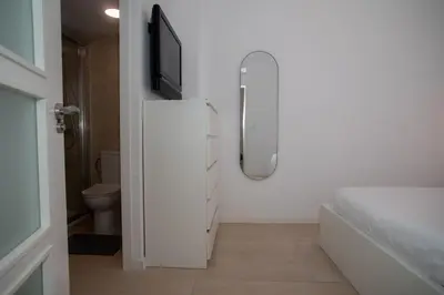 a bathroom with a tv on a white cabinet at Apartamento acogedor frente a Torres de Serrano in Valencia