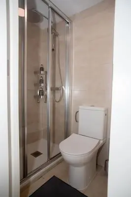 a white toilet in a bathroom with a shower at Apartamento acogedor frente a Torres de Serrano in Valencia