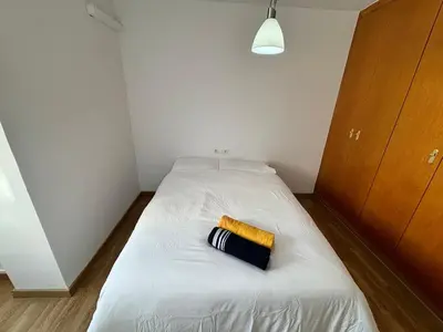 a small bedroom with a white bed with a yellow towel on it at Cute and Cosy Room in Valencia