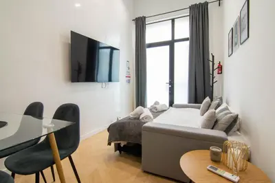 a living room with a couch and a table and a tv at Luxe Appartement in Valencia - Dichtbij strand in Valencia