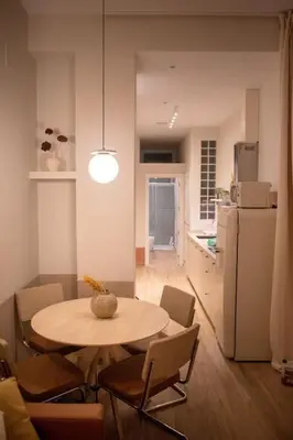 a kitchen with a table and chairs and a white refrigerator at Apartamento con terraza Junto a Ruzafa in Valencia