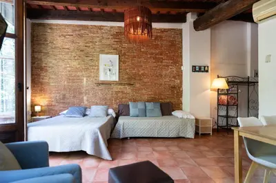 two beds in a room with a brick wall at Apartamentos Mercado Central in Valencia