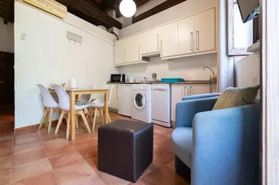 a living room with a couch and a table and a kitchen at Apartamentos Mercado Central in Valencia