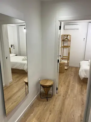 a mirror in a room with a bedroom at Apartamento acogedor frente a Plaza del Cedro in Valencia