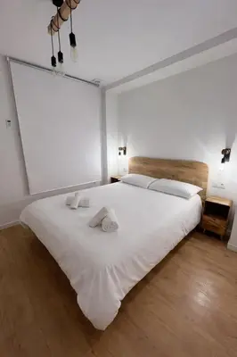 a bedroom with a large white bed with two pillows at Apartamento acogedor frente a Plaza del Cedro in Valencia