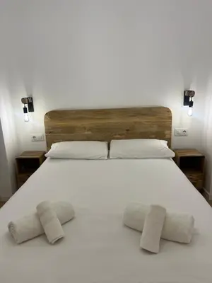 a large white bed with two pillows on it at Apartamento acogedor frente a Plaza del Cedro in Valencia
