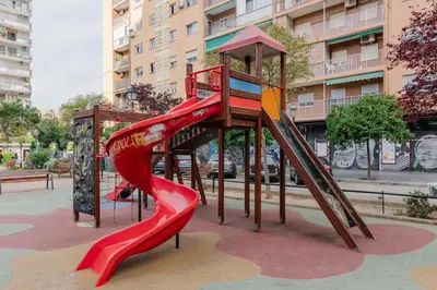 a playground with two slides and a play structure at Apartamento acogedor frente a Plaza del Cedro in Valencia