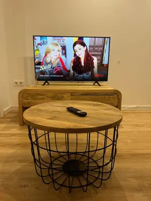 a table with a remote control in front of a television at Apartamento acogedor frente a Plaza del Cedro in Valencia