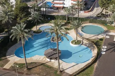 an overhead view of two pools with palm trees at Florazar 2 Apartamento frente al mar en Cullera in Cullera