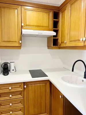 a kitchen with wooden cabinets and a sink at Florazar 2 Apartamento frente al mar en Cullera in Cullera