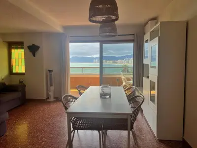a dining room with a table and chairs and a window at Florazar 2 Apartamento frente al mar en Cullera in Cullera