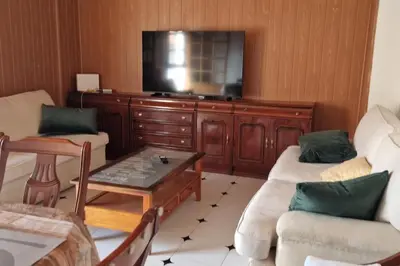 a living room with two couches and a flat screen tv at Ático en el casco histórico con increibles vistas de montaña in Higueruelas