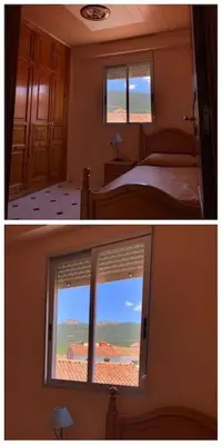 a bedroom with a bed and a window with a view at Ático en el casco histórico con increibles vistas de montaña in Higueruelas