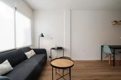 a living room with a black couch and a table at VLC HOST - Don Juan de Austria in Valencia