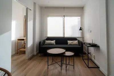 a living room with a black couch and a table at VLC HOST - Don Juan de Austria in Valencia