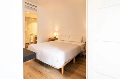 a bedroom with a white bed and a shower at VLC HOST - Don Juan de Austria in Valencia