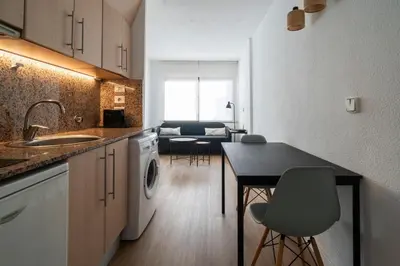 a kitchen and living room with a table and chairs at VLC HOST - Don Juan de Austria in Valencia