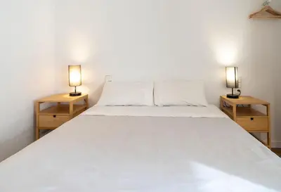 a bedroom with a large white bed with two lamps at VLC HOST - Don Juan de Austria in Valencia