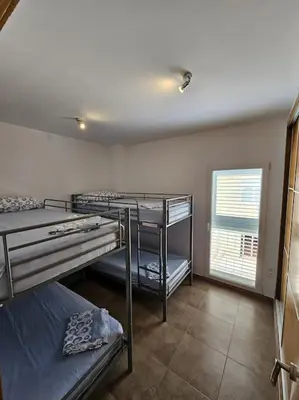 a room with three bunk beds and a window at Chalet frente al Mar in Cullera