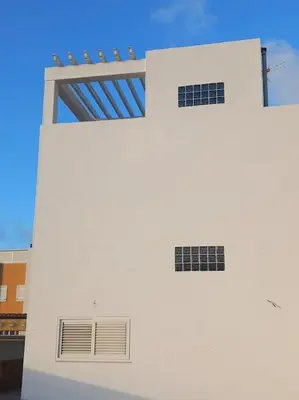 two windows on the side of a white building at Chalet frente al Mar in Cullera