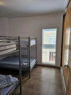 a room with three bunk beds and a window at Chalet frente al Mar in Cullera