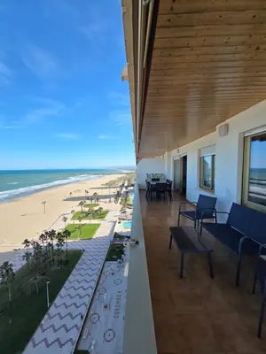 a view of a beach with palm trees and the ocean at Apartamento frente a la playa in Cullera