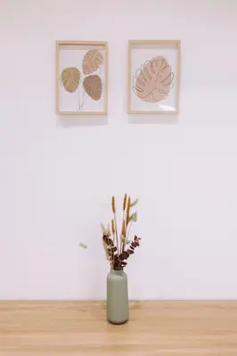 a vase sitting on a table with two pictures on the wall at Nuevo y moderno loft en amistat in Valencia