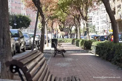 a bench on a sidewalk next to a street with cars at Valencia Sky Haven in Valencia