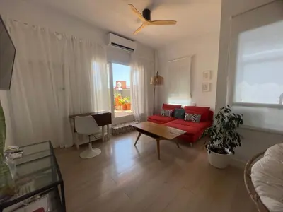 a living room with a red couch and a table at Valencia Sky Haven in Valencia
