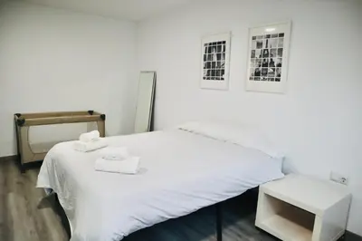 a bedroom with a white bed with two towels on it at Big Flat Ruzafa in Valencia