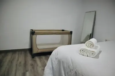 a bedroom with a bed with a mirror and towels at Big Flat Ruzafa in Valencia