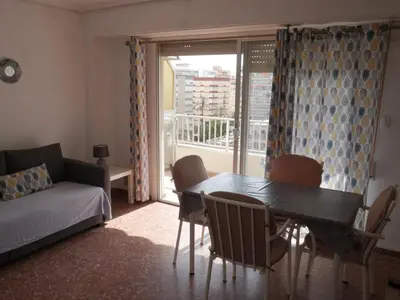 a living room with a table and chairs and a window at Malvarrosa, 8-54 in Cullera