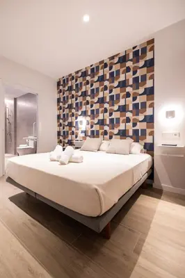 a bedroom with a large white bed with a wall at Yard Patraix by Concept Flats in Valencia