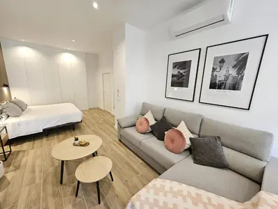 a living room with a couch and a bed and a table at HOB Las Ciencias II in Valencia