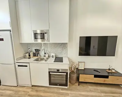a white kitchen with a sink and a refrigerator at HOB Las Ciencias II in Valencia