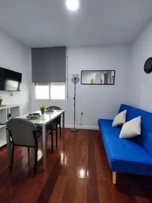 a living room with a blue couch and a table at Benimaclet Deluxe3 in Valencia