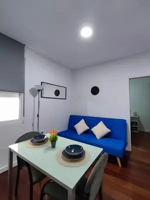 a living room with a blue couch and a table at Benimaclet Deluxe3 in Valencia