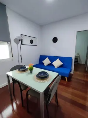 a living room with a table and a blue couch at Benimaclet Deluxe3 in Valencia