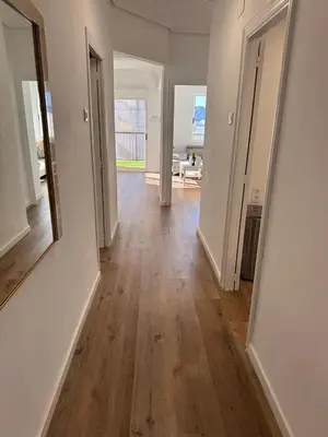 an empty hallway with white walls and wood floors at Arena apartment in Faro de Cullera