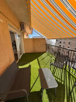 a balcony with two chairs and a bench and an umbrella at Arena apartment in Faro de Cullera
