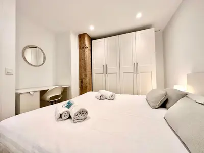 a bedroom with a large white bed with towels on it at Apartamento Hierros VLC in Valencia