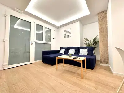 a living room with a blue couch and a table at Apartamento Hierros VLC in Valencia