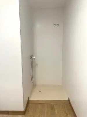 a bathroom with a shower with a white wall at Blue House Valencia in Valencia