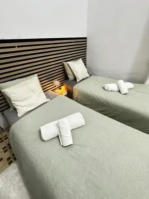 a room with two beds with white towels on them at 1- Habitación interior con aire acondicionado y con baño independiente in Valencia