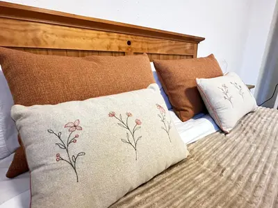 a bed with brown pillows and a wooden headboard at La Teja in Losa del Obispo