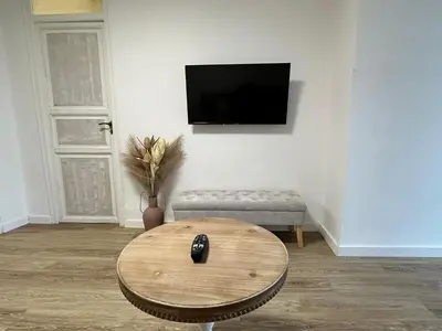a living room with a table and a tv on a wall at La Teja in Losa del Obispo