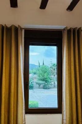 a window with yellow curtains in a room at La Teja in Losa del Obispo