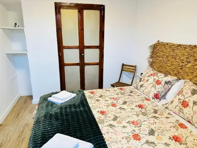 a bedroom with a bed with a table and a chair at La Teja in Losa del Obispo